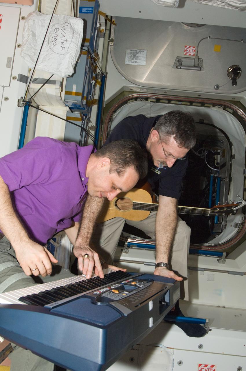 ISS030-E-267652 (21 April 2012) --- NASA astronaut Dan Burbank (with guitar), Expedition 30 commander, and Russian cosmonaut Anton Shkaplerov, flight engineer, are pictured at a musical keyboard during off-time in the Unity node of the International Space Station.