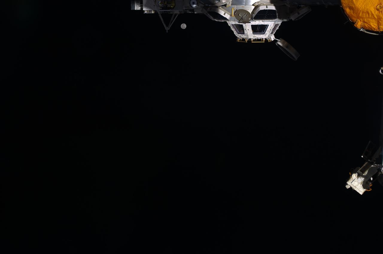 ISS031-E-018530 (6 May 2012) --- While most of the world's population had no trouble at all finding the full moon on the weekend of May 5-6, one has to look really closely to spot Earth's satellite in the space traveler's eye-view aboard the International Space Station, some 240 miles above Earth. The moon can be seen just to the left of the station's Cupola and just to the right of one of its solar array panels. While the photo was recorded around midnight on May 5 in the central daylight time zone, it was already early May 6 GMT.  Three Expedition 31 crew members await the arrival of three additional crewmates in a little more than a week.