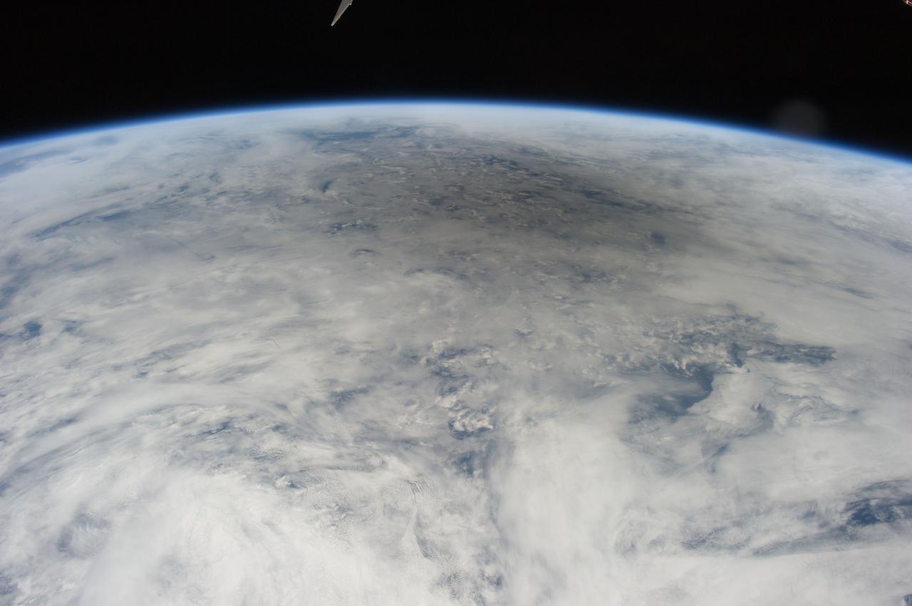 ISS031-E-041635 (20 May 2012) --- Photographed by the Expedition 31 crew aboard the International Space Station and easily spotted at top center in this image is the gray shadow of the moon, cast on bright clouds of the northern Pacific Ocean, as the May 20 solar eclipse point tracked towards the Aleutian Islands and then on to northern California. The eclipse is seen obliquely so it appears as a flattened circle. The eclipse was visible for about 3.5 hours, and since the ISS orbits Earth every 90 minutes there was a chance that the ISS crew would see (if not the total eclipse by looking directly overhead), some evidence at least in the form of a partial eclipse. Only since the start of human spaceflight could such an image have been shot, looking back at the moon’s shadow projected against Earth. As it happened, say NASA scientists, the timing was almost as good as if it had been planned. The space station passed “behind” the eclipse on May 20, that is, the shadow of the eclipse passed the point in the Northwest Pacific Ocean only three minutes before the station crossed the same point. But the crew was still able to see the densest part of the shadow a little more than 600 kilometers to the northeast of their position when they shot this photograph. The edge of the shadow looks diffused because of the partial eclipse zone—the wide area where more or less of the sun can be seen around the edge of the moon. The zone of partial eclipse covers a far wider area than the area covered by the total eclipse. Twenty-six minutes later, as they approached Antarctica in the other hemisphere, the six-member crew saw the sun set as they passed onto the dark side of the planet.