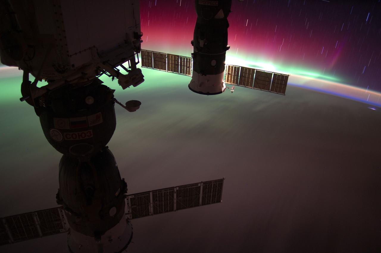ISS031-E-066037 (22 May 2012) --– Aurora Australis, accompanied by star streaks and air glow, is pictured in this view recorded by one of the Expedition 31 crew members when the orbital outpost was above a point on Earth located at approximately 49.5 degrees south latitude and 173.9 east longitude or about 290 miles southeast of southern New Zealand. Two Russian spacecraft, docked to the station, are seen in the foreground.