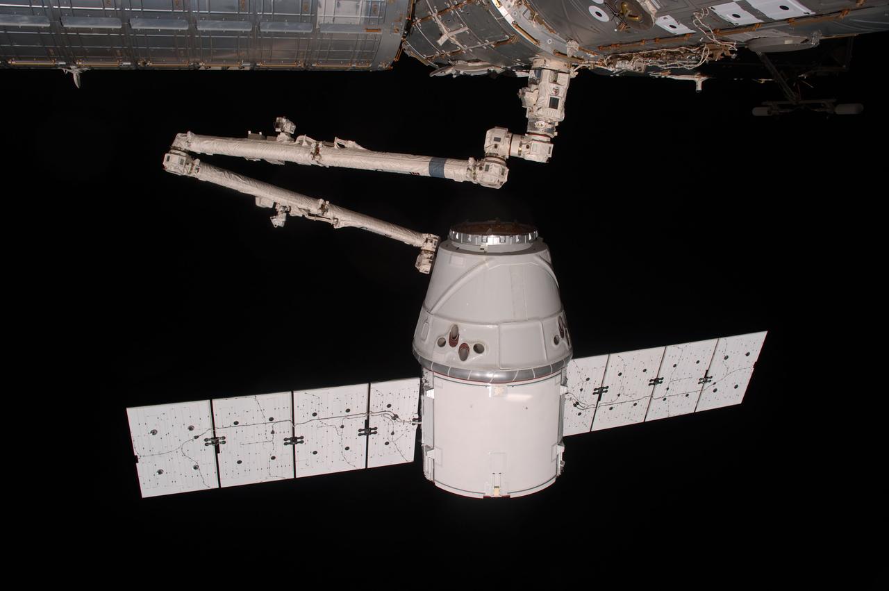 ISS031-E-070804 (25 May 2012) --- The SpaceX Dragon commercial cargo craft is grappled by the Canadarm2 robotic arm at the International Space Station. Expedition 31 Flight Engineers Don Pettit and Andre Kuipers grappled Dragon at 9:56 a.m. (EDT) and used the robotic arm to berth Dragon to the Earth-facing side of the station’s Harmony node at 12:02 p.m. May 25, 2012. Dragon became the first commercially developed space vehicle to be launched to the station to join Russian, European and Japanese resupply craft that service the complex while restoring a U.S. capability to deliver cargo to the orbital laboratory. Dragon is scheduled to spend about a week docked with the station before returning to Earth on May 31 for retrieval.