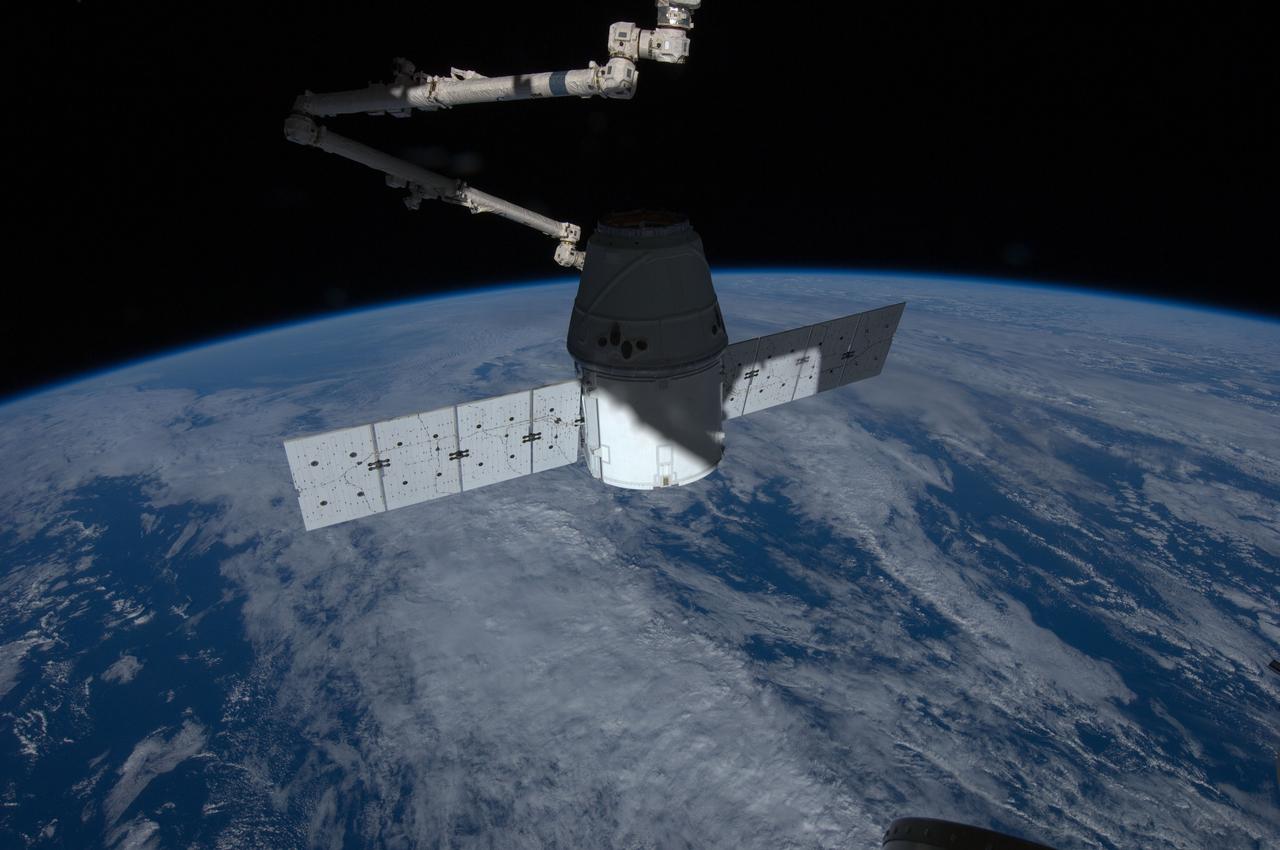 ISS031-E-071547 (25 May 2012) --- The SpaceX Dragon commercial cargo craft is berthed to the Earth-facing side of the International Space Station’s Harmony node. Expedition 31 Flight Engineers Don Pettit and Andre Kuipers grappled Dragon at 9:56 a.m. (EDT) with the Canadarm2 robotic arm and used it to berth Dragon to the at 12:02 p.m. May 25, 2012. Dragon became the first commercially developed space vehicle to be launched to the station to join Russian, European and Japanese resupply craft that service the complex while restoring a U.S. capability to deliver cargo to the orbital laboratory. Dragon is scheduled to spend about a week docked with the station before returning to Earth on May 31 for retrieval.