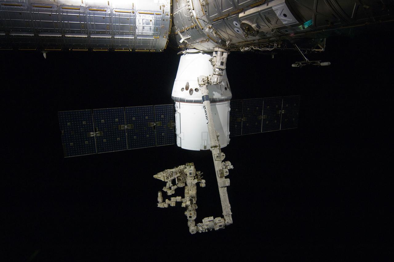 ISS031-E-077666 (25 May 2012) --- The SpaceX Dragon commercial cargo craft is berthed to the Earth-facing side of the International Space Station’s Harmony node. Expedition 31 Flight Engineers Don Pettit and Andre Kuipers grappled Dragon at 9:56 a.m. (EDT) with the Canadarm2 robotic arm and used it to berth Dragon to the at 12:02 p.m. May 25, 2012. Dragon became the first commercially developed space vehicle to be launched to the station to join Russian, European and Japanese resupply craft that service the complex while restoring a U.S. capability to deliver cargo to the orbital laboratory. Dragon is scheduled to spend about a week docked with the station before returning to Earth on May 31 for retrieval.