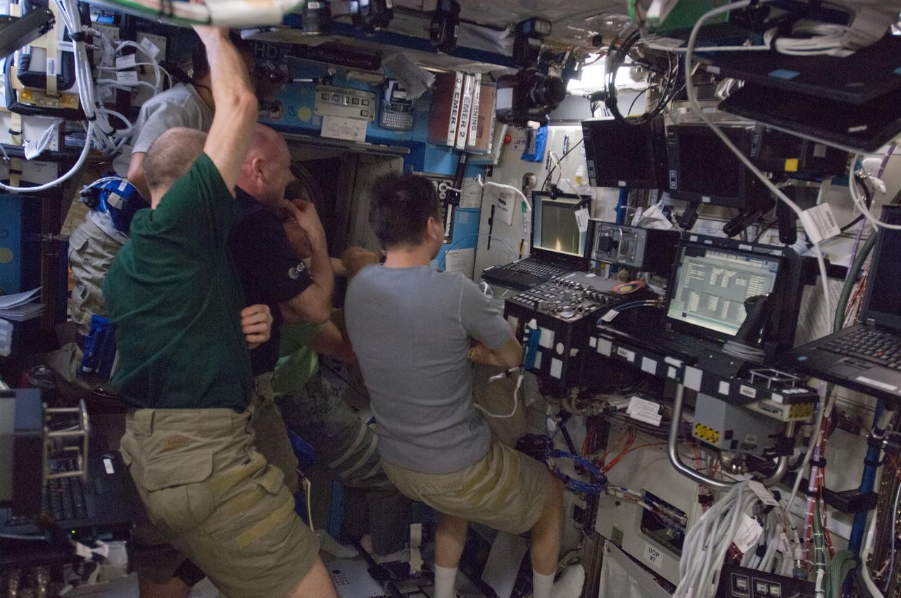 ISS031-E-140390 (22 May 2012) --- Expedition 31 crew members watch the launch of the SpaceX Falcon 9 rocket on a computer monitor in the Destiny laboratory of the International Space Station on May 22, 2012. Pictured clockwise (from bottom right) are Russian cosmonaut Oleg Kononenko, commander; NASA astronaut Don Pettit, European Space Agency astronaut Andre Kuipers, NASA astronaut Joe Acaba, Russian cosmonauts Sergei Revin (obscured) and Gennady Padalka, all flight engineers.
