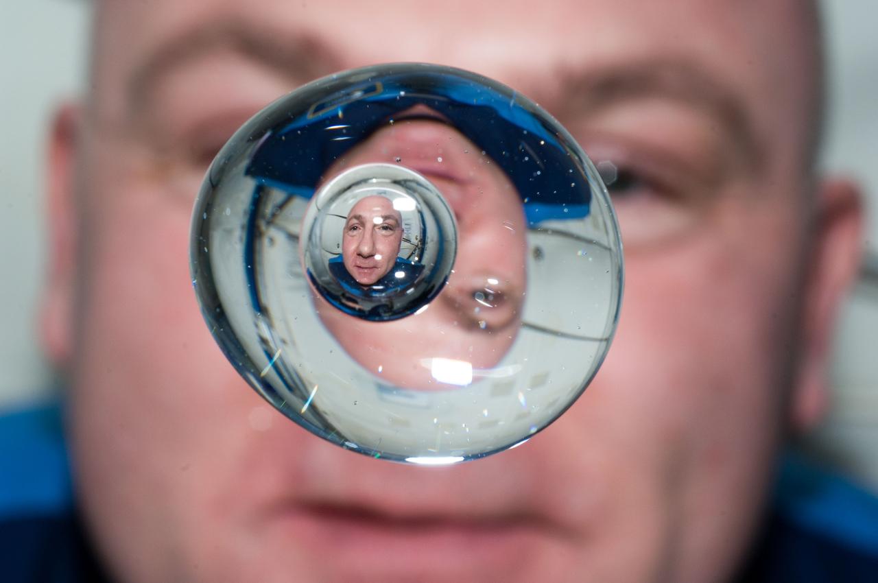 ISS031-E-143875 (24 June 2012) --- European Space Agency astronaut Andre Kuipers, Expedition 31 flight engineer, watches a water bubble float freely between him and the camera, showing his image refracted and reflected, on the International Space Station.
