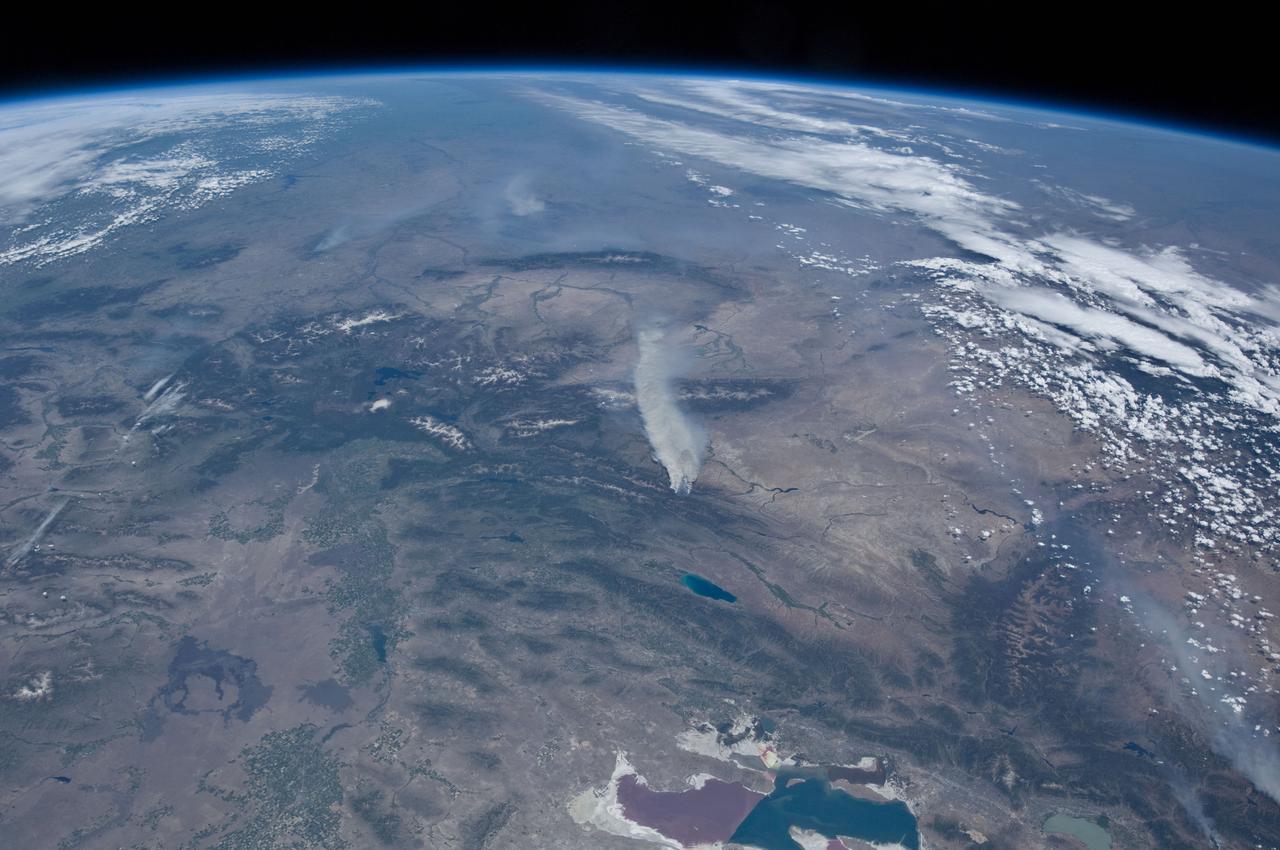 ISS031-E-146391 (27 June 2012) --- An Expedition 31 crew member aboard the International Space Station, flying approximately 240 miles above Earth, recorded a series of images of the current wild fires in the western and southwestern United States. These particular fires, of unknown cause, are burning at the south end of the Wyoming Range in southwestern Wyoming, and have affected 17,000 acres. The fires have produced two major smoke plumes, seen at center of the frame. Utah?s Great Salt Lake (bottom center) is about 120 miles away. Winds transport the smoke in a northeasterly direction.