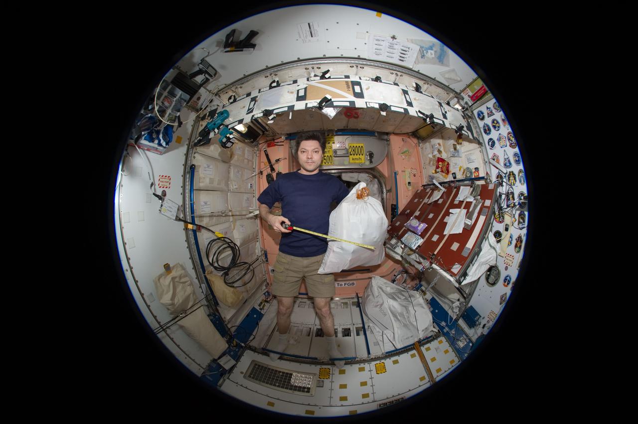 ISS031-E-148931 (28 June 2012) --- A fisheye lens attached to an electronic still camera was used to capture this image of Russian cosmonaut Oleg Kononenko, Expedition 31 commander, during stowage operations in the Unity node of the International Space Station.