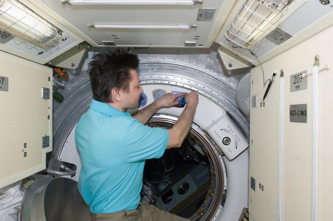 ISS031-E-150059 (28 June 2012) --- In the Rassvet Mini-Research Module 1 (MRM-1),  Russian cosmonaut Oleg Kononenko, Expedition 31 commander, adds the Soyuz TMA-03M patch to the growing collection of insignias representing crews who have worked on the International Space Station.