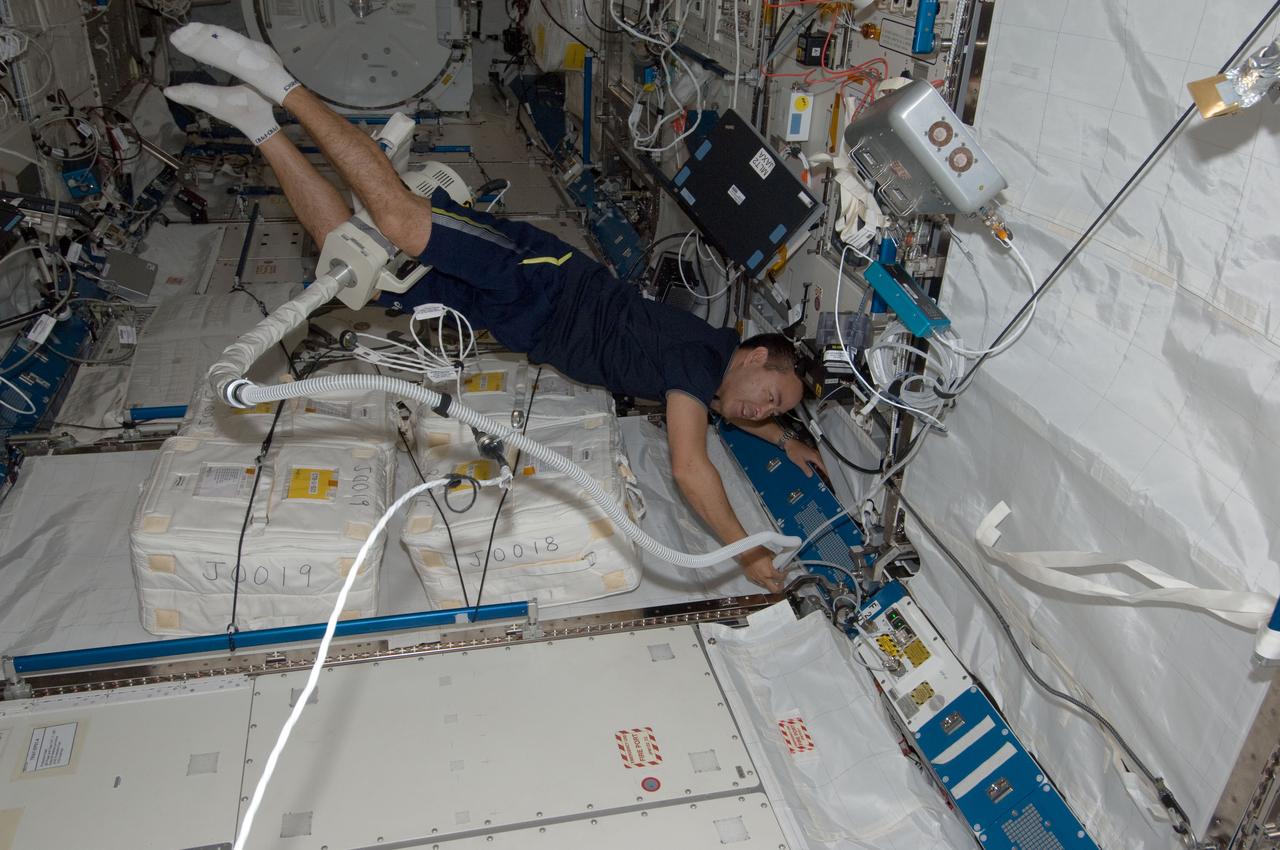 ISS032-E-010377 (28 July 2012) --- Japan Aerospace Exploration Agency astronaut Aki Hoshide, Expedition 32 flight engineer, uses a vacuum cleaner during housekeeping operations in the Kibo laboratory of the International Space Station.