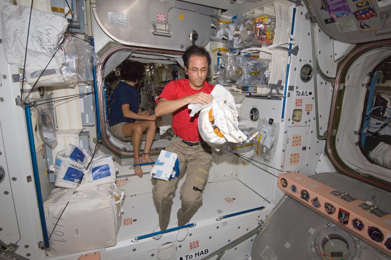 ISS032-E-011058 (31 July 2012) --- NASA astronaut Joe Acaba, Expedition 32 flight engineer, works with a stowage container in the Unity node of the International Space Station. NASA astronaut Sunita Williams, flight engineer, is visible in the background.
