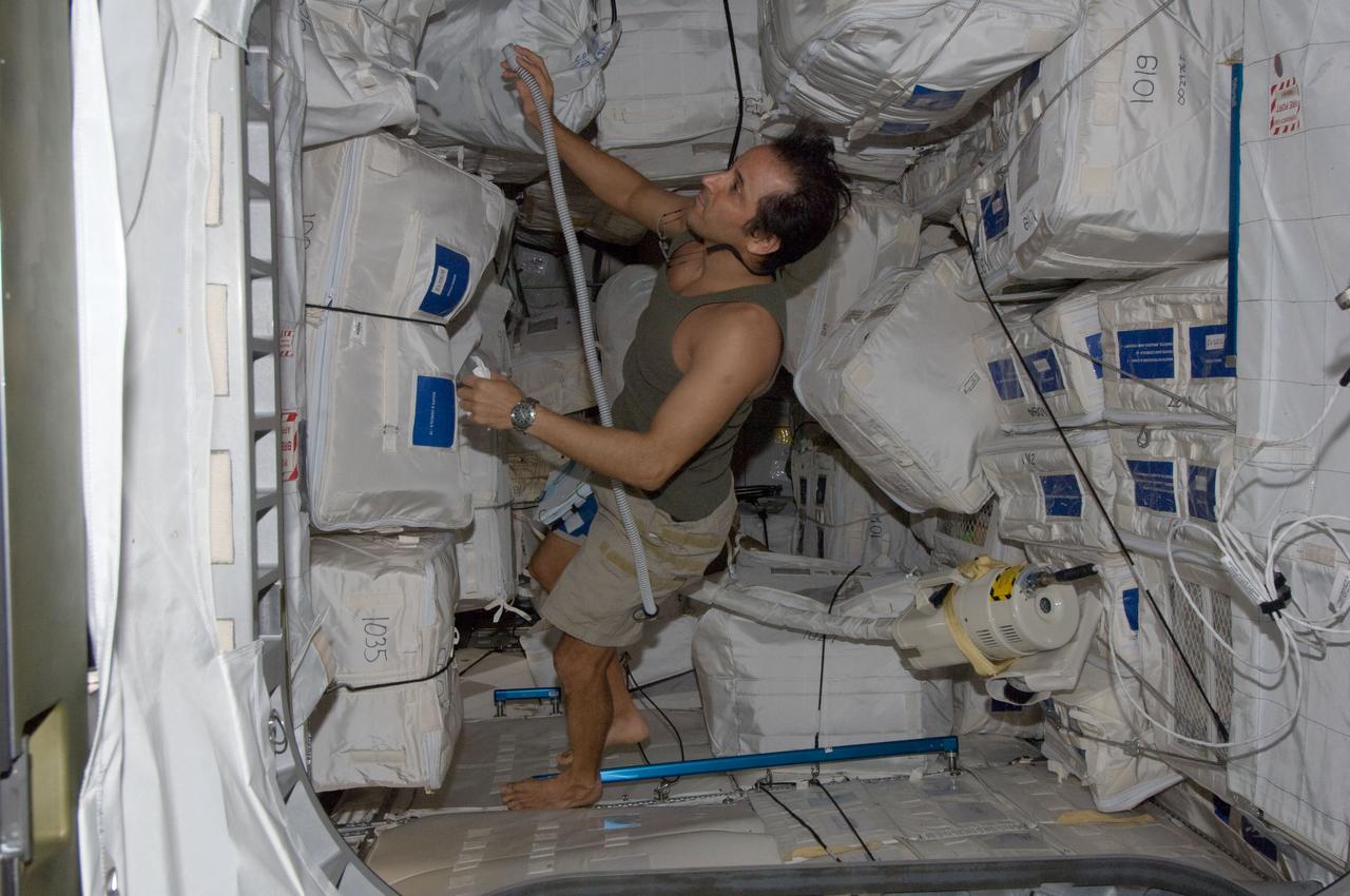 ISS032-E-011881 (4 Aug. 2012) --- NASA astronaut Joe Acaba, Expedition 32 flight engineer, uses a vacuum cleaner during housekeeping operations in the Permanent Multipurpose Module (PMM) of the International Space Station.