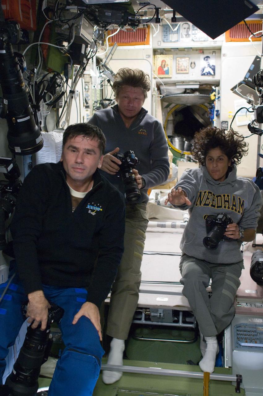 ISS032-E-016776 (9 Aug. 2012) --- Russian cosmonaut Gennady Padalka (center), Expedition 32 commander; along with Russian cosmonaut Yuri Malenchenko and NASA astronaut Sunita Williams, both flight engineers, are pictured holding still cameras in the Zvezda Service Module of the International Space Station.