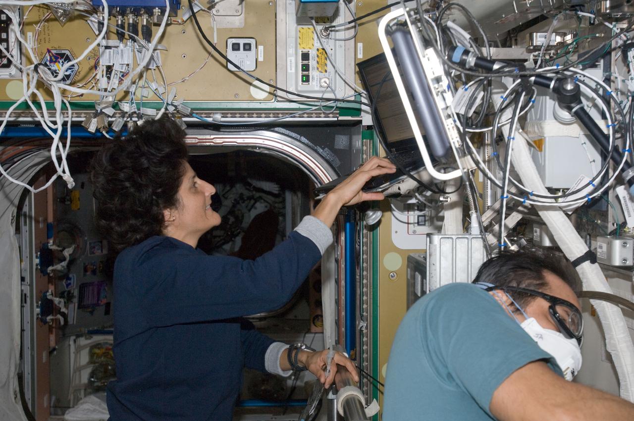 ISS032-E-016881 (10 Aug. 2012) --- NASA astronauts Sunita Williams and Joe Acaba, both Expedition 32 flight engineers, work in the Destiny laboratory of the International Space Station.