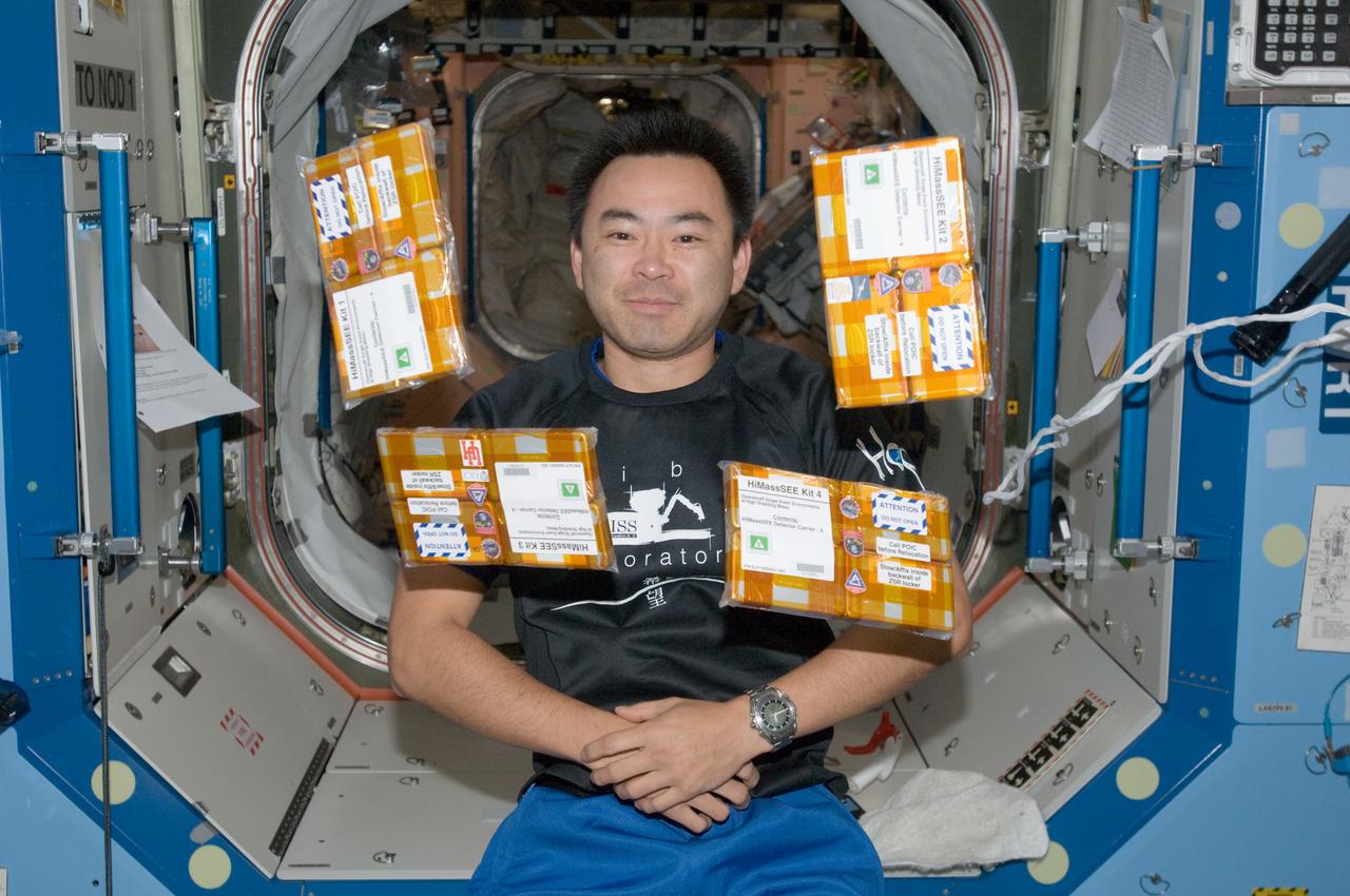 iss032e016946 (8/11/2012) --- Japan Aerospace Exploration Agency (JAXA) astronaut Akihiko Hoshide poses with the HiMassSEE (Spacecraft Single Event Environments at High Shielding Mass) kits 1,2,3 and 4 in the U.S. Lab aboard the International Space Station (ISS). Spacecraft Single Event Environments at High Shielding Mass (HiMassSEE) measures space radiation interactions with spacecraft structure and shielding using several passive track detector technologies to provide a more accurate definition of International Space Station (ISS) payload accommodations, radiation transport model validation, and flight demonstration data on advanced microelectronics and chemical dosimeters.