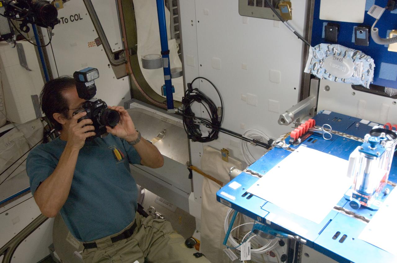 ISS032-E-016966 (10 Aug. 2012) --- NASA astronaut Joe Acaba, Expedition 32 flight engineer, uses a still camera while conducting a session with the Capillary Flow Experiment (CFE) Vane Gap-2 (VG2) in the Harmony node of the International Space Station. CFE observes the flow of fluid, in particular capillary phenomena, in microgravity.