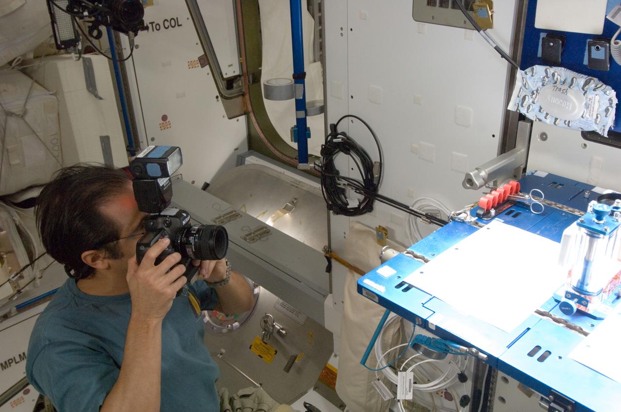 ISS032-E-016967 (10 Aug. 2012) --- NASA astronaut Joe Acaba, Expedition 32 flight engineer, uses a still camera while conducting a session with the Capillary Flow Experiment (CFE) Vane Gap-2 (VG2) in the Harmony node of the International Space Station. CFE observes the flow of fluid, in particular capillary phenomena, in microgravity.