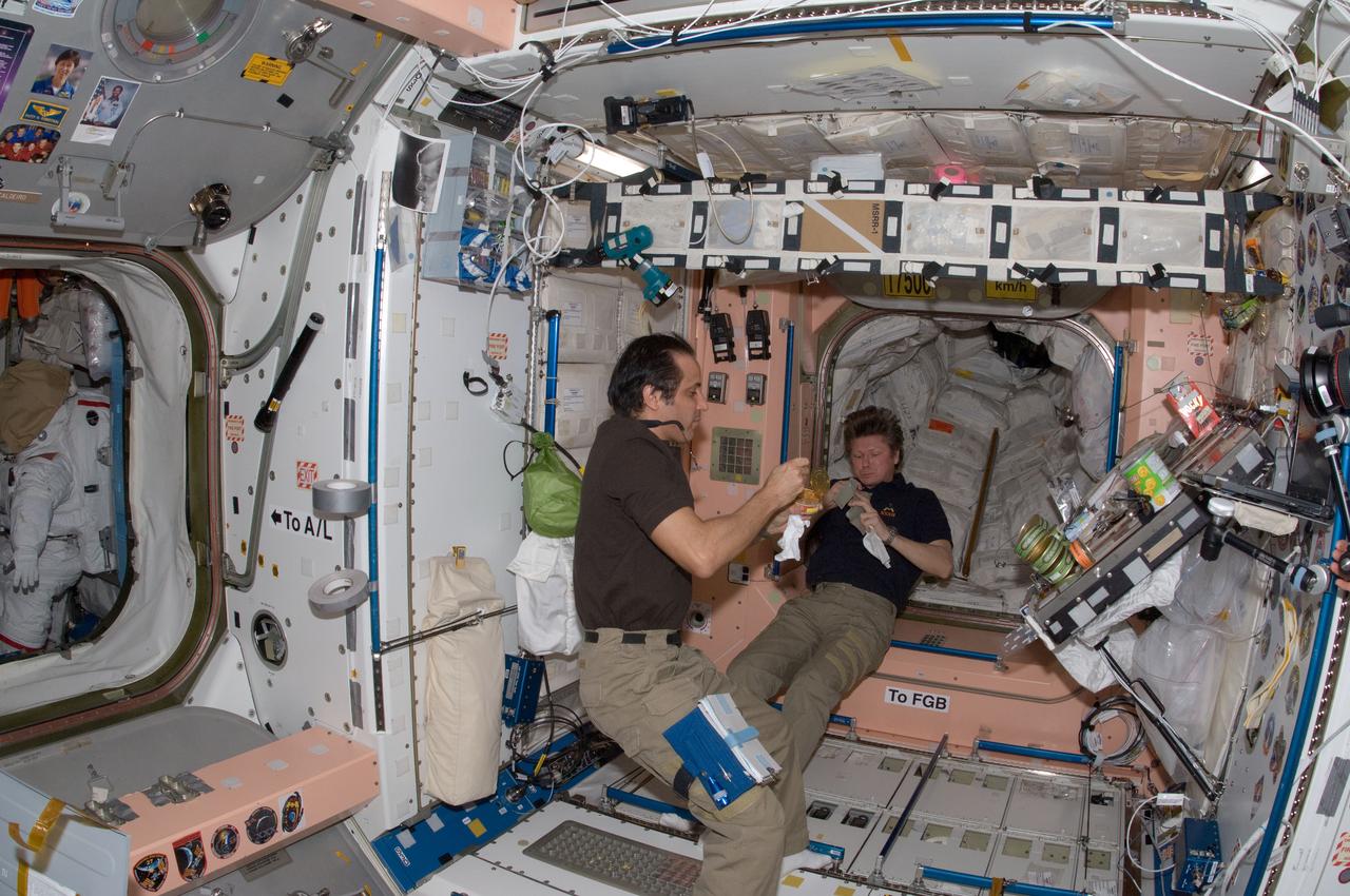 ISS032-E-018203 (13 Aug. 2012) --- Russian cosmonaut Gennady Padalka (right), Expedition 32 commander; and NASA astronaut Joe Acaba, flight engineer, eat a snack near the galley in the Unity node of the International Space Station.