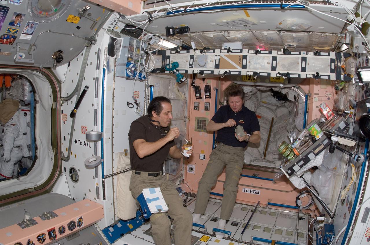 ISS032-E-018205 (13 Aug. 2012) --- Russian cosmonaut Gennady Padalka (right), Expedition 32 commander; and NASA astronaut Joe Acaba, flight engineer, eat a snack near the galley in the Unity node of the International Space Station.