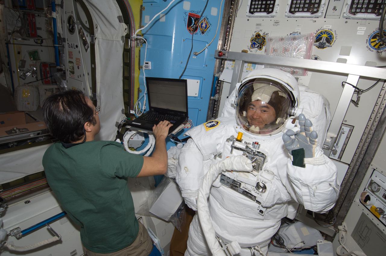 ISS032-E-022926 (22 Aug. 2012) --- In the International Space Station?s Quest airlock, Japan Aerospace Exploration Agency astronaut Aki Hoshide (attired in an Extravehicular Mobility Unit (EMU) spacesuit) and NASA astronaut Joe Acaba, both Expedition 32 flight engineers, prepare for a spacewalk scheduled for Aug. 30.
