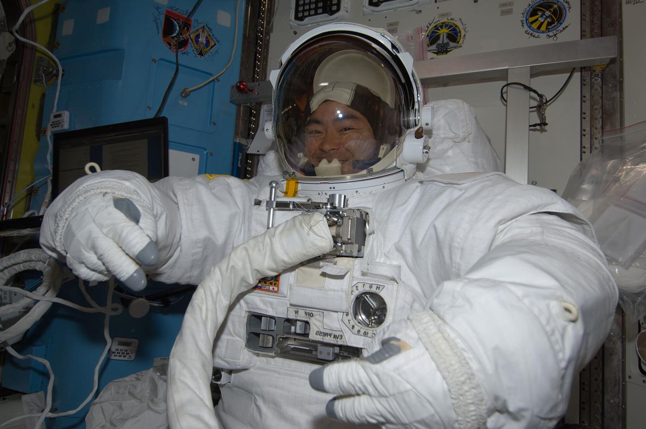 ISS032-E-022931 (22 Aug. 2012) --- In the International Space Station?s Quest airlock, Japan Aerospace Exploration Agency astronaut Aki Hoshide, Expedition 32 flight engineer, attired in an Extravehicular Mobility Unit (EMU) spacesuit, prepares for a spacewalk scheduled for Aug. 30.