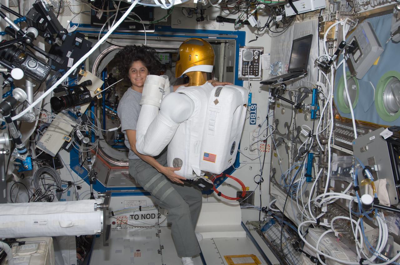 ISS032-E-022952 (22 Aug. 2012) --- NASA astronaut Sunita Williams, Expedition 32 flight engineer, works with Robonaut 2 humanoid robot in the Destiny laboratory of the International Space Station.