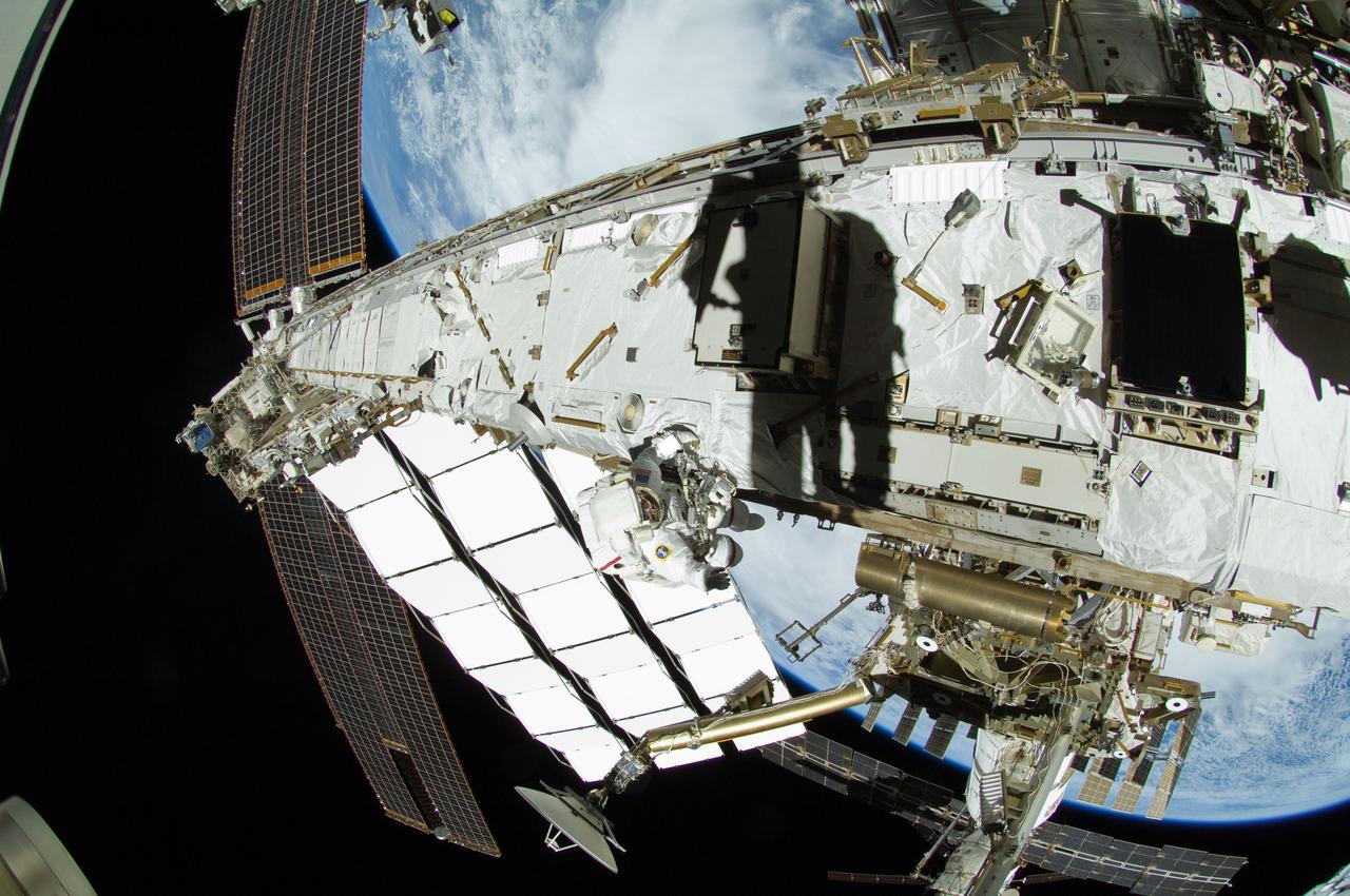 ISS032-E-024154 (30 Aug. 2012) --- NASA astronaut Sunita Williams (center frame) and Japan Aerospace Exploration Agency astronaut Aki Hoshide (seen as silhouette to the right of Williams), both Expedition 32 flight engineers, participate in a session of extravehicular activity (EVA) to continue outfitting the International Space Station.
