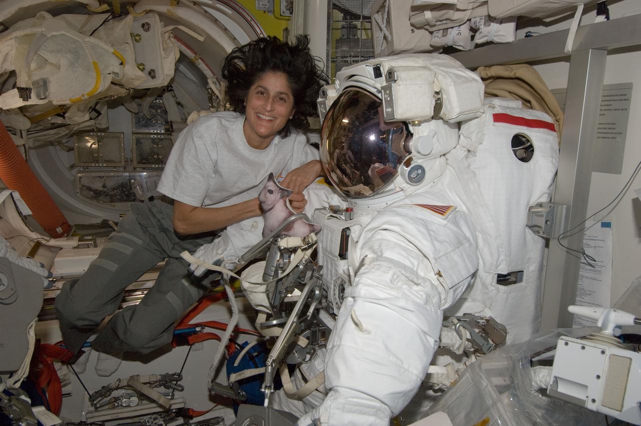 ISS032-E-024600 (29 Aug. 2012) --- NASA astronaut Sunita Williams, Expedition 32 flight engineer, poses for a photo with her Extravehicular Mobility Unit (EMU) spacesuit in the Quest airlock of the International Space Station.