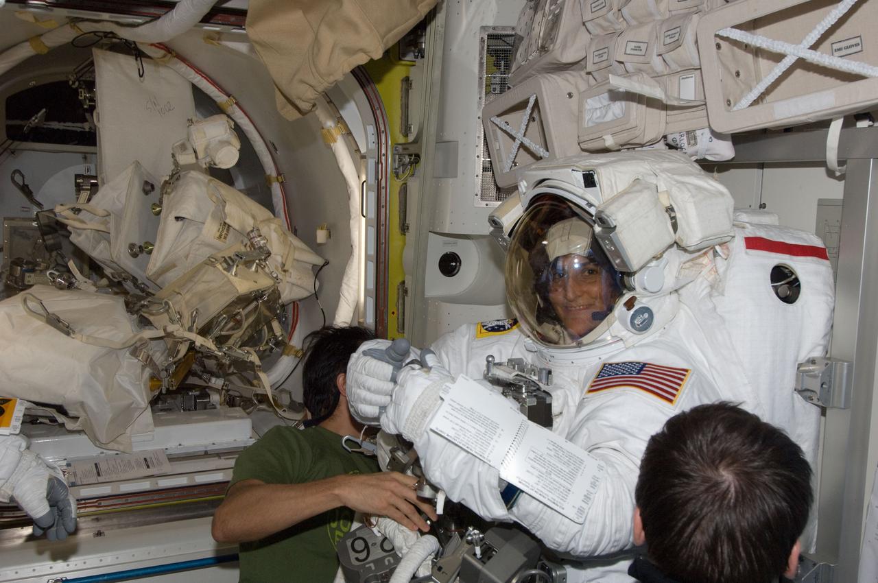 ISS032-E-024619 (30 Aug. 2012) --- NASA astronaut Joe Acaba (partially obscured), Russian cosmonaut Yuri Malenchenko (right foreground), NASA astronaut Sunita Williams and Japan Aerospace Exploration Agency astronaut Aki Hoshide (out of frame), all Expedition 32 flight engineers, prepare for the start of the mission?s second session of extravehicular activity (EVA) in the International Space Station?s Quest airlock. Williams is attired in her Extravehicular Mobility Unit (EMU) spacesuit.