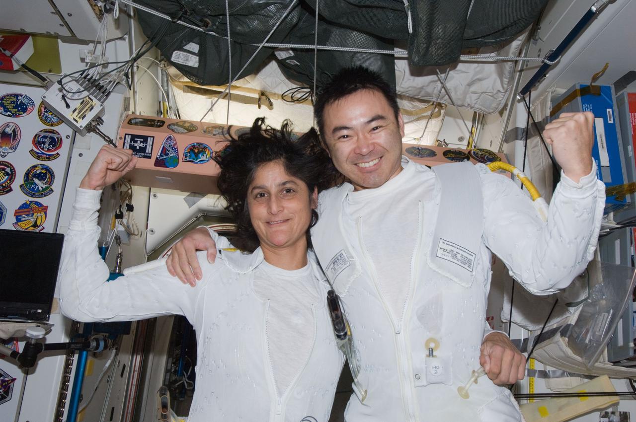 ISS032-E-025361 (5 Sept. 2012) --- Having doffed the outer layer of their Extravehicular Mobility Unit (EMU) spacesuits, Expedition 32 Flight Engineers Sunita Williams of NASA and Akihiko Hoshide of the Japan Aerospace Exploration Agency (JAXA) flex their muscles, celebrating success on their just-completed spacewalk, the second extravehicular activity for them in less than a week. They are still sporting their EMU thermal underwear in the Unity Node 1.