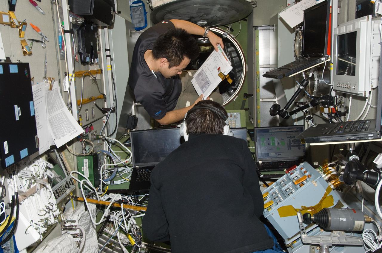 ISS033-E-007419 (25 Sept. 2012) --- Japan Aerospace Exploration Agency astronaut Aki Hoshide (top) and Russian cosmonaut Yuri Malenchenko, both Expedition 33 flight engineers, work in the Zvezda Service Module of the International Space Station.
