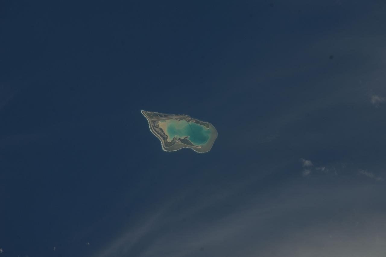 ISS033-E-007873 (27 Sept. 2012) --- Wake Island is featured in this image photographed by an Expedition 33 crew member on the International Space Station. The atoll of Wake Island is located in the central Pacific Ocean approximately 4,000 kilometers to the west-southwest of Hawaii and 2,400 kilometers to the northwest of Guam. In addition to Wake Island, the atoll includes the smaller Peale and Wilkes Island for a total land surface area of 6.5 square kilometers. Like many atolls in the Pacific, the islands and associated reefs formed around a submerged volcano. The lagoon in the center of the islands—characterized by shallow, light blue water in contrast to the surrounding darker, deeper Pacific Ocean waters—marks the approximate location of the summit crater of the volcano.