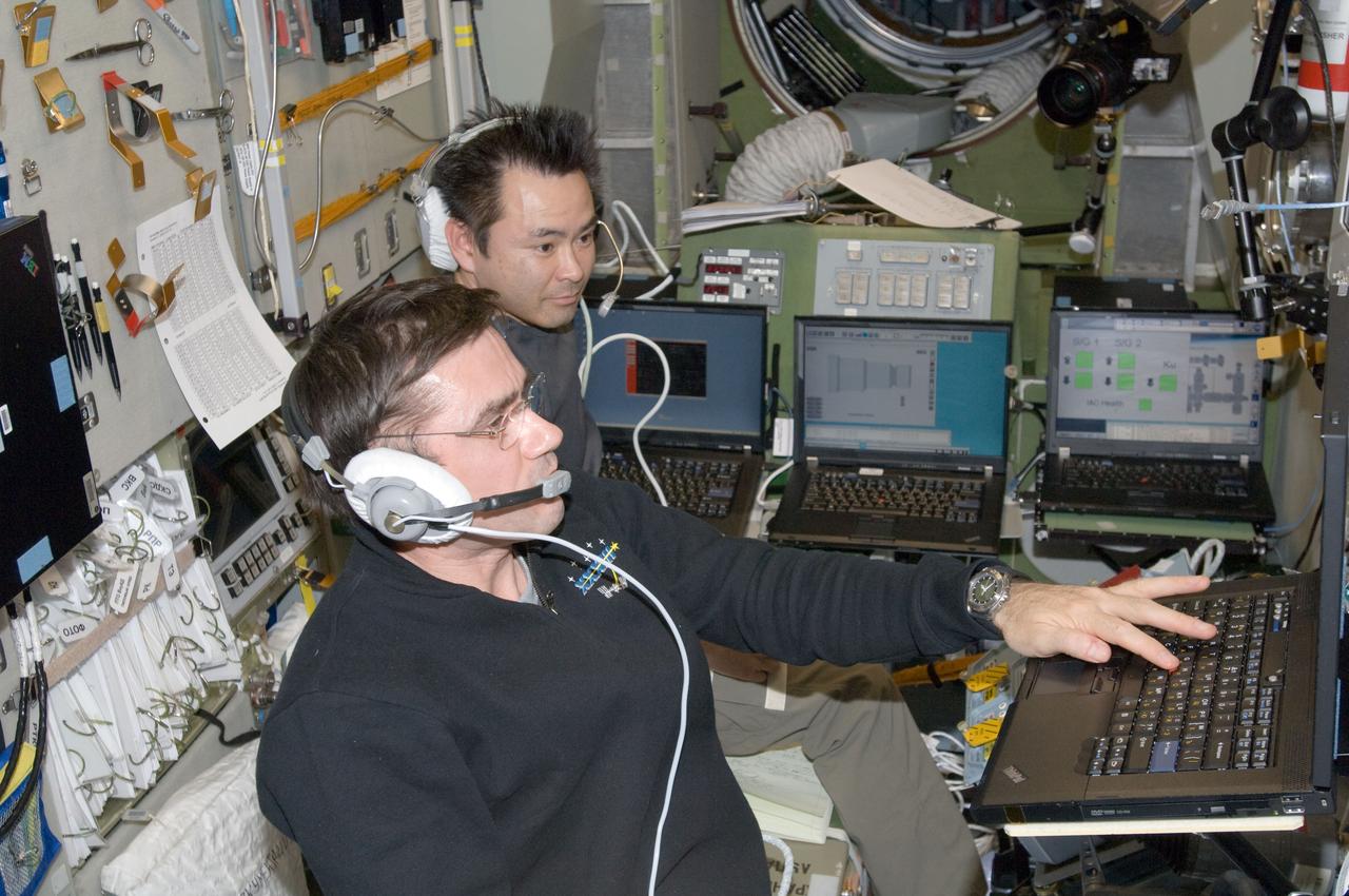 ISS033-E-008178 (28 Sept. 2012) --- In the Zvezda Service Module, Russian cosmonaut Yuri Malenchenko (foreground) and Japan Aerospace Exploration Agency astronaut Aki Hoshide, both Expedition 33 flight engineers, monitor the undocking of the European Space Agency's "Edoardo Amaldi" Automated Transfer Vehicle-3 (ATV-3) from the International Space Station.