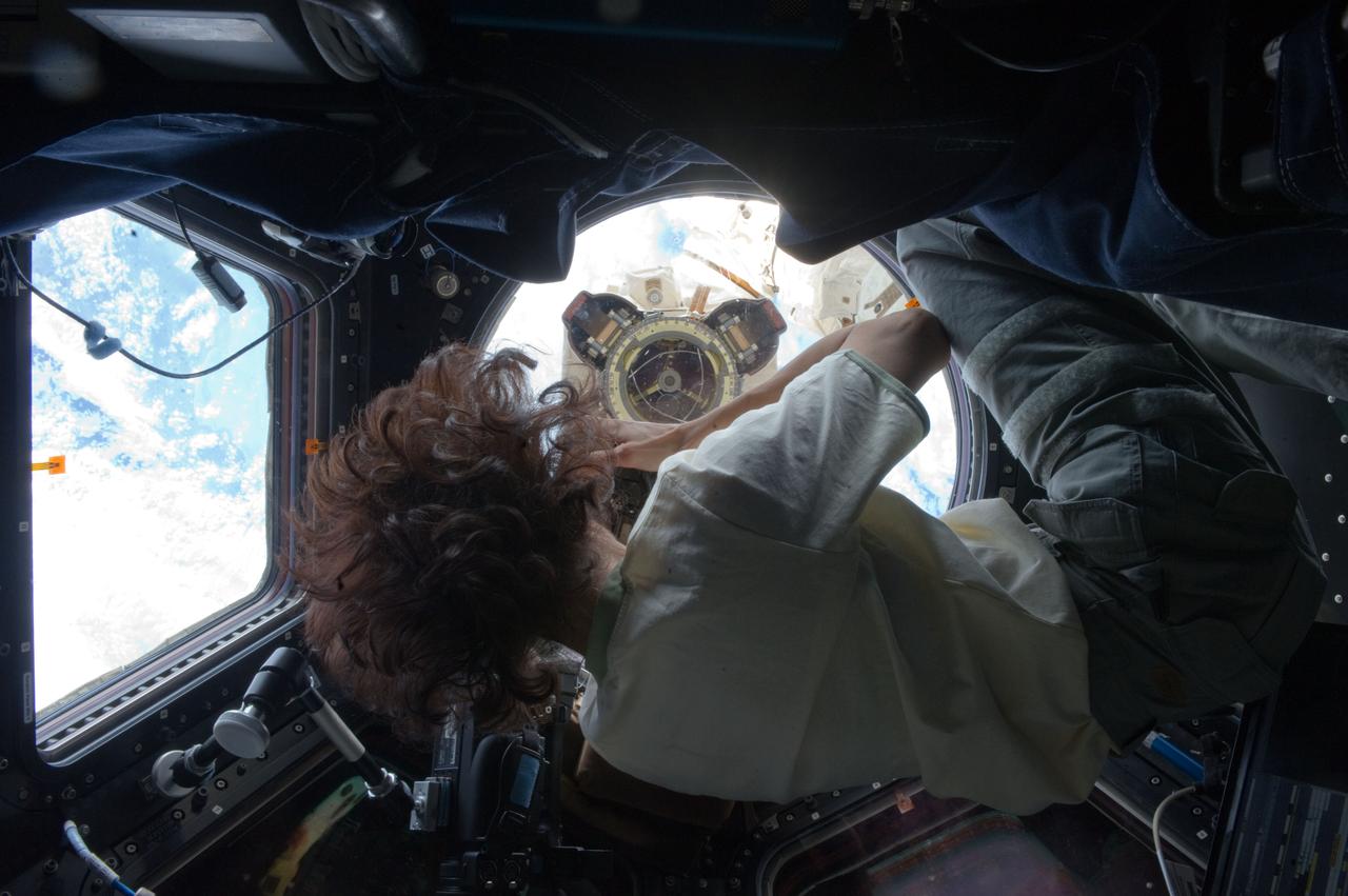 ISS033-E-012340 (16 Oct. 2012) --- NASA astronaut Sunita Williams, Expedition 33 commander, uses a still camera to photograph the Canadarm2 robotic arm?s Latching End Effector (LEE) from a window in the Cupola of the International Space Station.