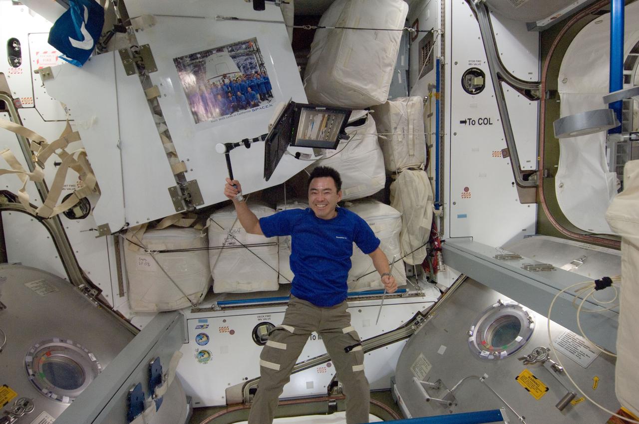 ISS033-E-013091 (14 Oct. 2012) --- Japan Aerospace Exploration Agency astronaut Aki Hoshide, Expedition 33 flight engineer, holds a computer attached to a stand in the Harmony node of the International Space Station. A signed poster of SpaceX personnel floats freely at upper left.