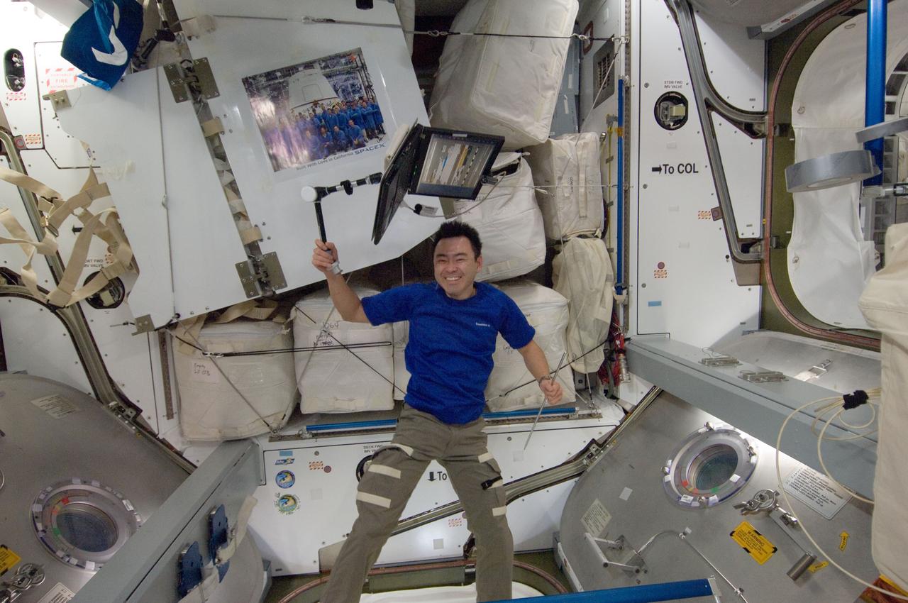 ISS033-E-013092 (14 Oct. 2012) --- Japan Aerospace Exploration Agency astronaut Aki Hoshide, Expedition 33 flight engineer, holds a computer attached to a stand in the Harmony node of the International Space Station. A signed poster of SpaceX personnel floats freely at upper left.