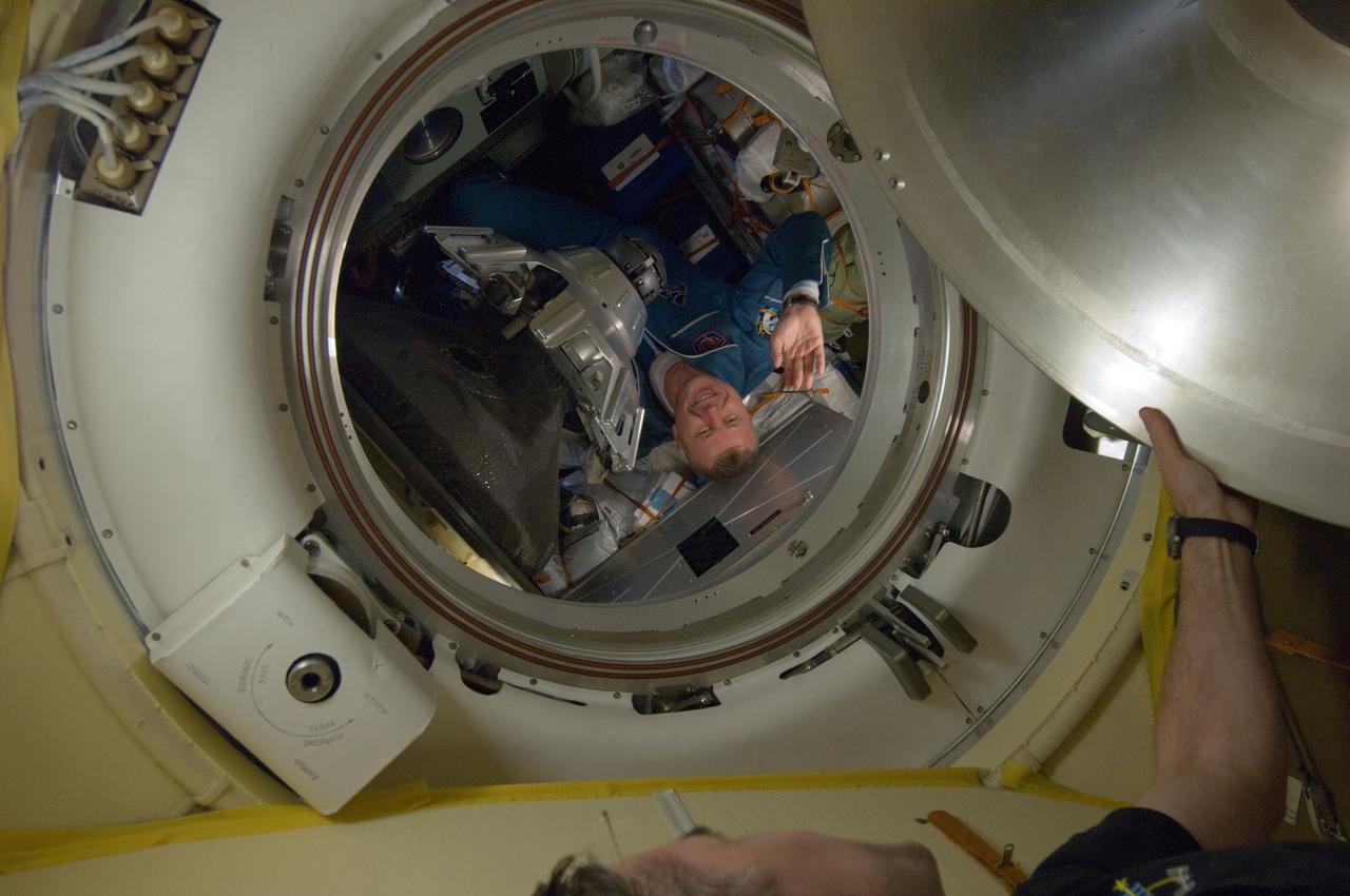 ISS033-E-016668 (25 Oct. 2012) --- Russian cosmonaut Oleg Novitskiy, Expedition 33 flight engineer, waves as he prepares to ingress the International Space Station’s Poisk Mini-Research Module 2 (MRM2) along with NASA astronaut Kevin Ford and Russian cosmonaut Evgeny Tarelkin (both out of frame). The Soyuz TMA-06M spacecraft carrying the three new Expedition 33 crew members docked at 8:29 a.m. (EDT) on Oct. 25, 2012.