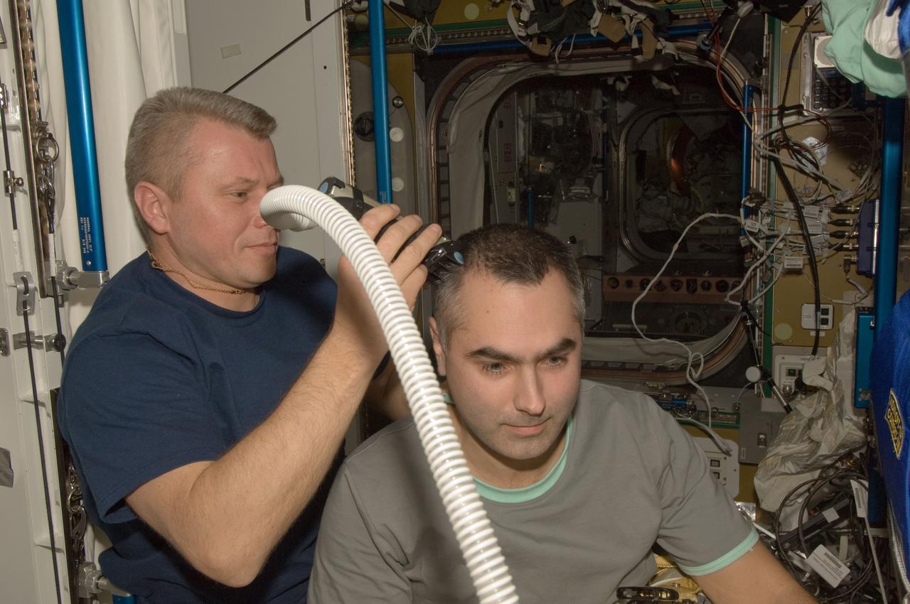 ISS033-E-018991 (10 Nov. 2012) --- Russian cosmonaut Oleg Novitskiy, Expedition 33 flight engineer, trims the hair of Russian cosmonaut Evgeny Tarelkin, flight engineer, in the Tranquility node of the International Space Station. Novitskiy used hair clippers fashioned with a vacuum device to garner freshly cut hair.