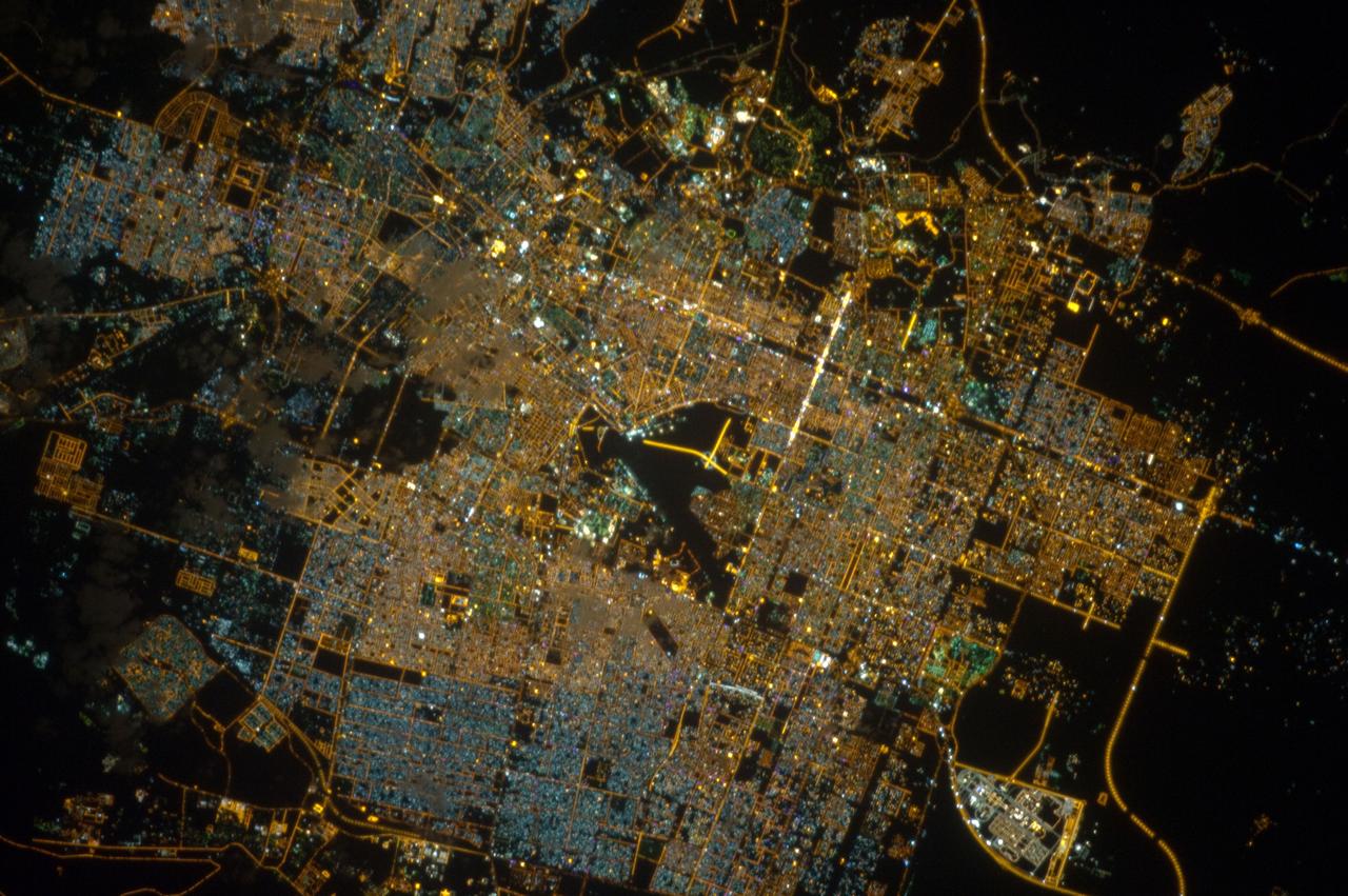 ISS033-E-020288 (13 Nov. 2012) --- A nighttime view of Riyadh, Saudi Arabia is featured in this image photographed by an Expedition 33 crew member on the International Space Station. The population of Riyadh, the capital city of Saudi Arabia, has risen dramatically in the last half century, from 150,000 in 1960 to an estimated 5.4 million in 2012. The city appears as a brightly colored patchwork in this nighttime photograph. The brightest lights, apart from those on the old Riyadh Airbase at center (the new international airport is far outside the city and not shown here), follow the commercial districts along King Abdullah Road and King Fahd Branch Road. Many of the darker patches within the built area are city parks. University sectors stand out with different street and light patterns, as seen in the King Saud University campus which houses the Arabic Language Institute, and the Princess Nora Bint Abdul Rahman University which is the largest all-female university in the world. Highways and various ring roads also stand out in night imagery due to bright regular lighting. Lighted developments beyond the ring roads mark the growth of the city. Newer neighborhoods, set further from the city center, are recognizable by blue-gray lightning.