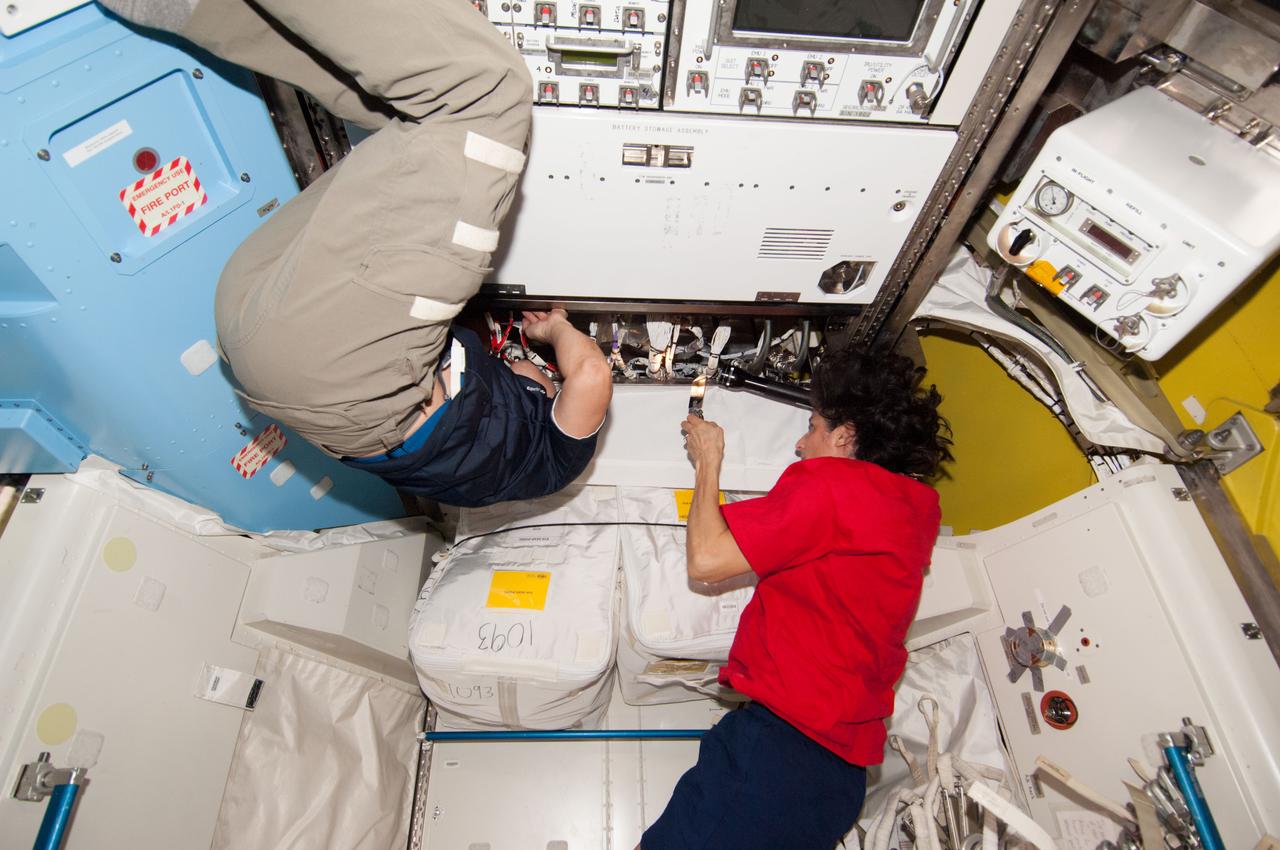 ISS033-E-021537 (14 Nov. 2012) --- NASA astronaut Sunita Williams, Expedition 33 commander; and Japan Aerospace Exploration Agency astronaut Aki Hoshide, flight engineer, perform in-flight maintenance in the Quest airlock of the International Space Station.