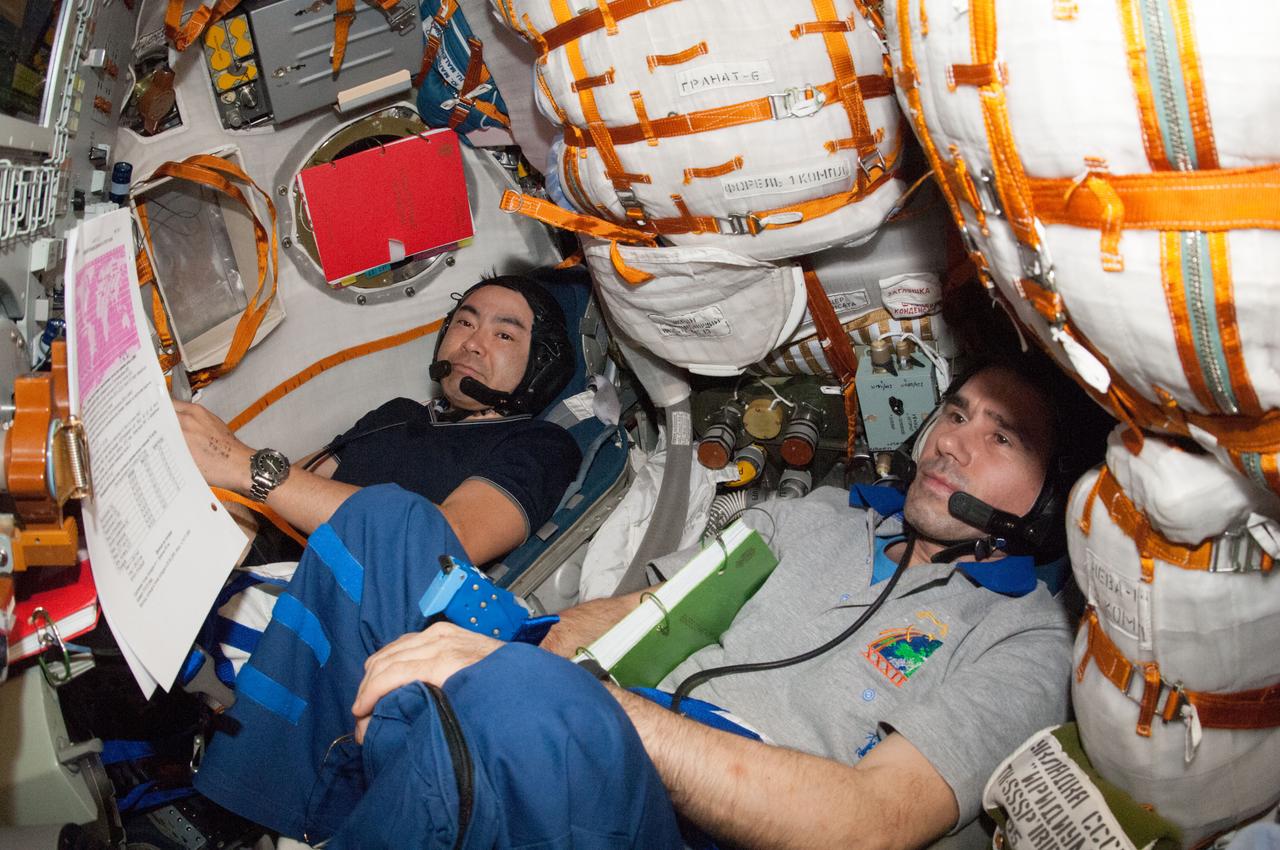 ISS033-E-021661 (16 Nov. 2012) --- Russian cosmonaut Yuri Malenchenko (right), Soyuz commander and Expedition 33 flight engineer; Japan Aerospace Exploration Agency astronaut Aki Hoshide, flight engineer; and NASA astronaut Sunita Williams (out of frame), Expedition 33 commander, participate in a standard training exercise in the Soyuz TMA-05M spacecraft in preparation for their return to Earth scheduled for Nov. 18, 2012 (U.S. time).
