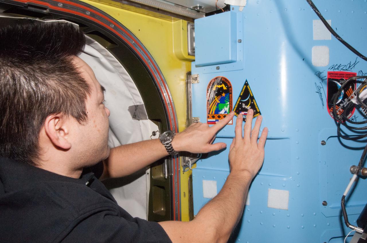 ISS033-E-022117 (18 Nov. 2012) --- Japan Aerospace Exploration Agency astronaut Aki Hoshide, Expedition 33 flight engineer, adds the Expedition 33 patch to the growing collection of insignias representing crews who performed spacewalks from the Quest airlock of the International Space Station.