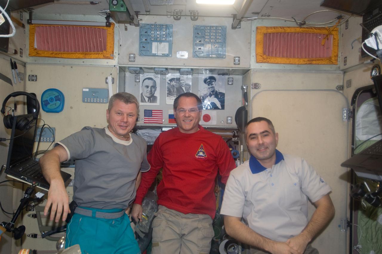 ISS034-E-005219 (21 Nov. 2012) --- NASA astronaut Kevin Ford (center), Expedition 34 commander; along with Russian cosmonauts Oleg Novitskiy (left) and Evgeny Tarelkin, both flight engineers, pose for a photo in the Zvezda Service Module of the International Space Station.