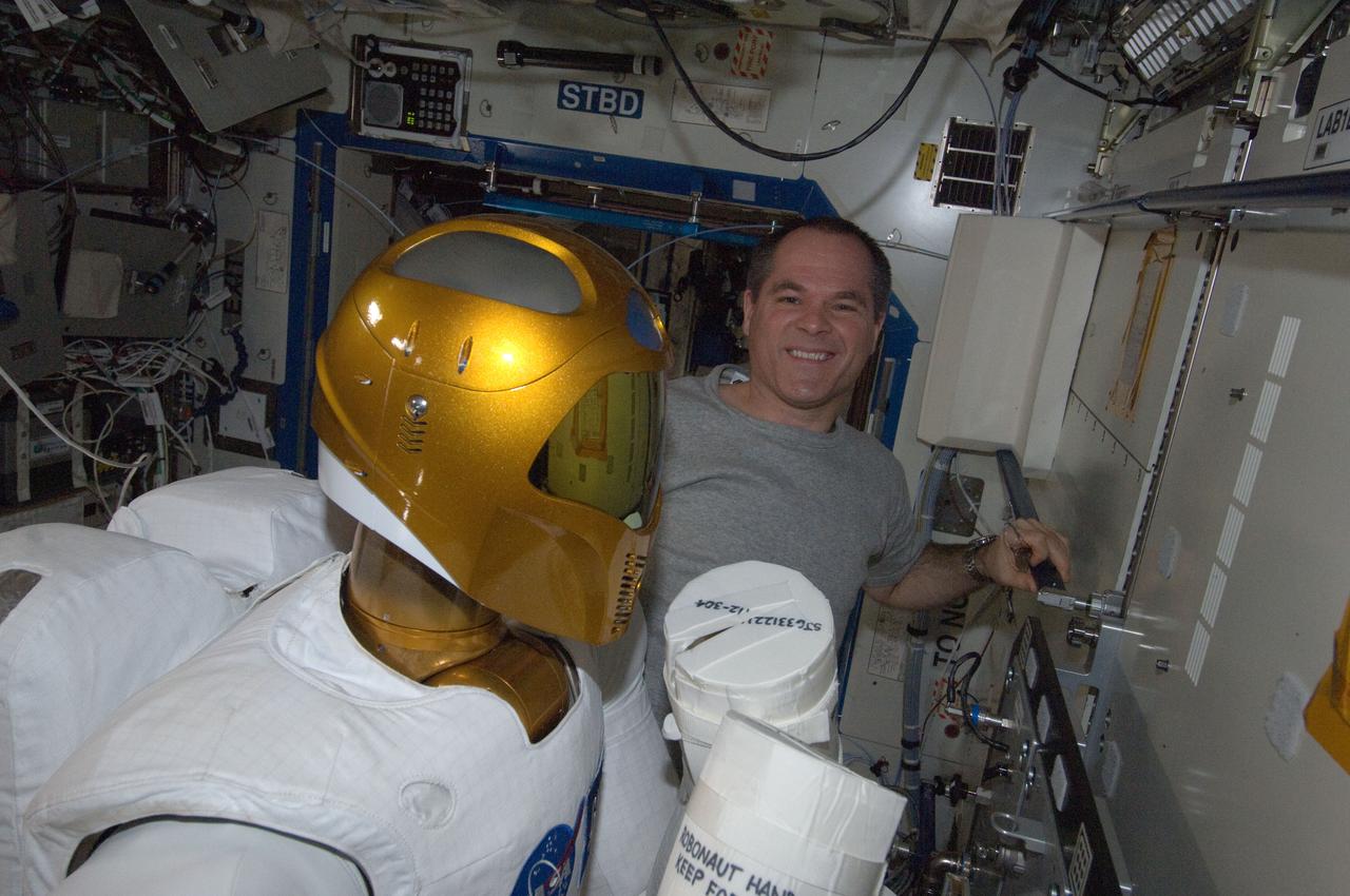 ISS034-E-007386 (10 Dec. 2012) --- NASA astronaut Kevin Ford, Expedition 34 commander, works with Robonaut 2 humanoid robot in the Destiny laboratory of the International Space Station.