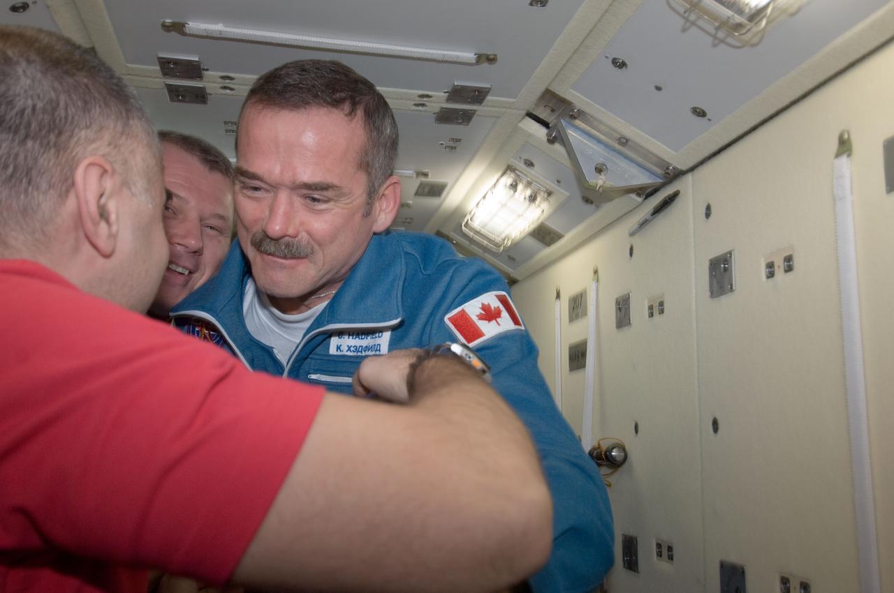 ISS034-E-009562 (21 Dec. 2012) --- Canadian Space Agency astronaut Chris Hadfield greets two Russian cosmonauts onboard the International Space Station moments after coming aboard on Dec. 21, 2012. The cosmonauts are Oleg Novitskiy (partially obscured at center) and Evgeny Tarelkin, both Expedition 34 flight engineers. Hadfield, along with a NASA astronaut and a Russian cosmonaut, launched on Dec. 19 aboard the Soyuz TMA-07M spacecraft.