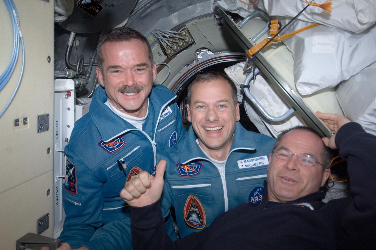 ISS034-E-009571 (21 Dec. 2012) --- Expedition 34 Commander Kevin Ford (right) of NASA welcomes astronauts Chris Hadfield and Tom Marshburn aboard the International Space Station on docking day -- Dec. 21, 2012. Hadfield, representing the Canadian Space Agency, and NASA's Marshburn launched in the Soyuz TMA-07M spacecraft on Dec. 19 to join the three-man crew already onboard the orbital outpost.