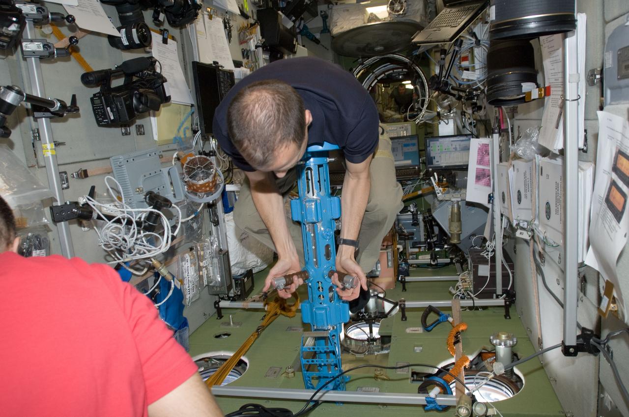 ISS034-E-009700 (23 Dec. 2012) --- Newly arrived Expedition 34 Flight Engineer Tom Marshburn, NASA astronaut, uses the Body Mass Measurement Device in the Zvezda service module aboard the International Space Station on Dec. 23, 2012. Marshburn, along with Canadian astronaut Chris Hadfield and Russian cosmonaut Roman Romanenko, arrived at the orbital outpost on Dec. 21 to join three other crewmen already onboard.