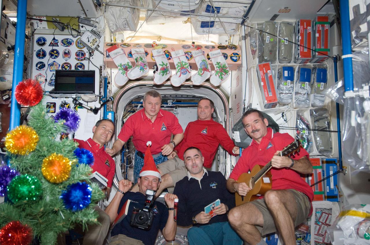 ISS034-E-010476 (24 Dec. 2012) --- Expedition 34 crew members assemble in the Unity node of the International Space Station for a brief celebration of the Christmas holiday. Pictured clockwise (from top right) are NASA astronaut Kevin Ford, commander; Canadian Space Agency astronaut Chris Hadfield, Russian cosmonauts Evgeny Tarelkin and Roman Romanenko, NASA astronaut Tom Marshburn and Russian cosmonaut Oleg Novitskiy, all flight engineers.