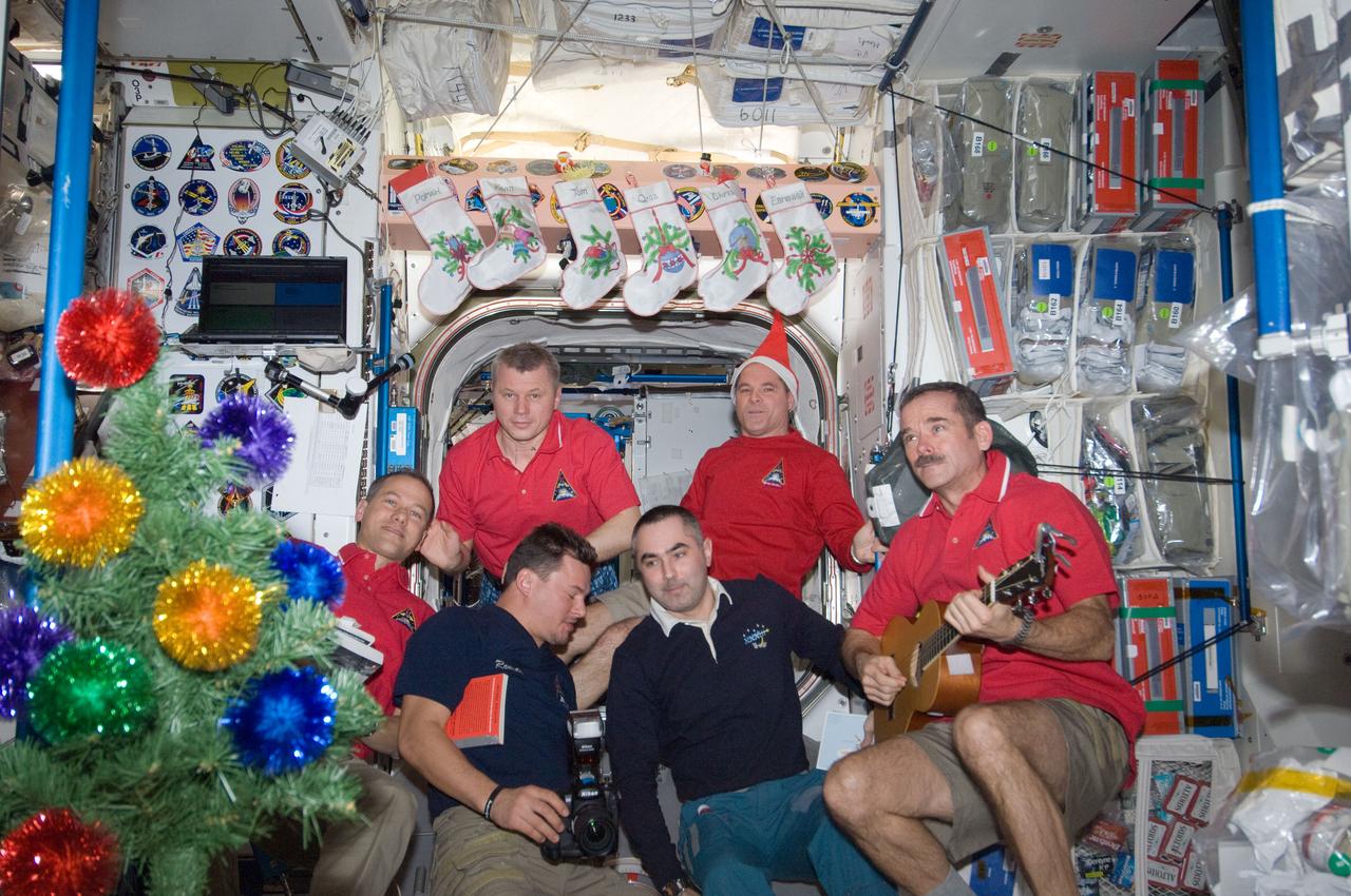 ISS034-E-010478 (24 Dec. 2012) --- Expedition 34 crew members assemble in the Unity node of the International Space Station for a brief celebration of the Christmas holiday. Pictured clockwise (from top right) are NASA astronaut Kevin Ford, commander; Canadian Space Agency astronaut Chris Hadfield, Russian cosmonauts Evgeny Tarelkin and Roman Romanenko, NASA astronaut Tom Marshburn and Russian cosmonaut Oleg Novitskiy, all flight engineers.