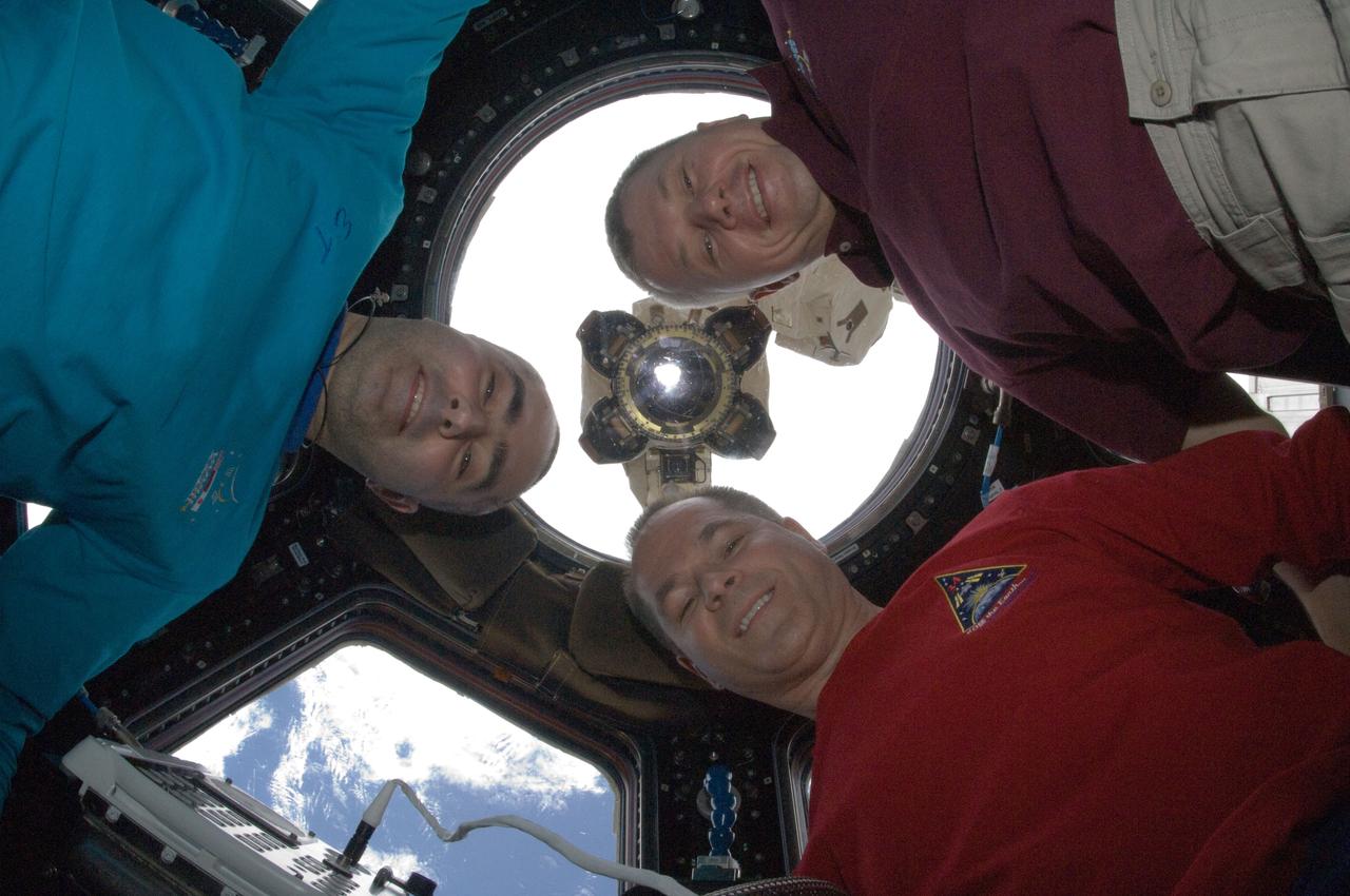 ISS034-E-010953 (27 Nov. 2012) --- NASA astronaut Kevin Ford (lower right), Expedition 34 commander; along with Russian cosmonauts Evgeny Tarelkin (left) and Oleg Novitskiy, both flight engineers, pose for a photo in the Cupola of the International Space Station. The Canadarm2 robotic arm's Latching End Effector (LEE) is visible through a window in the background.