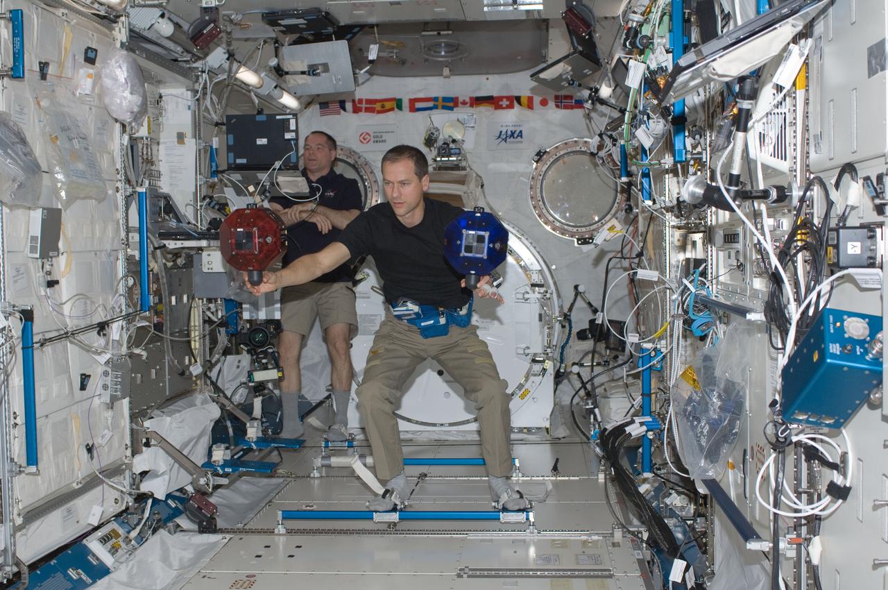 ISS034-E-014543 (4 Jan. 2013) --- With their feet anchored in floor restraints, NASA astronauts Kevin Ford (background), Expedition 34 commander; and Tom Marshburn, flight engineer, conduct a session of the Synchronized Position Hold, Engage, Reorient, Experimental Satellites (SPHERES) program in the Kibo laboratory of the International Space Station.